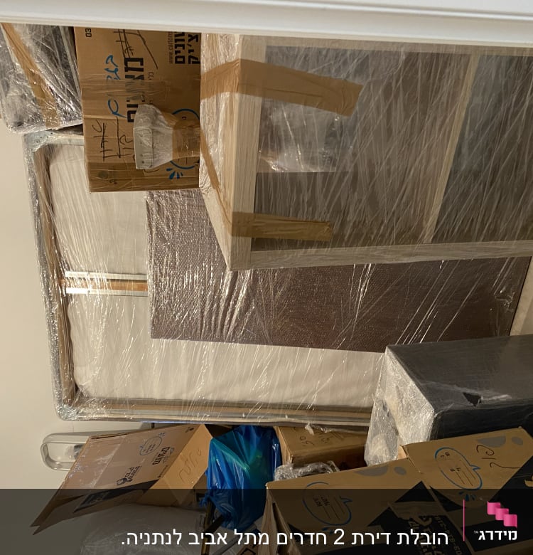 ארגזים ופריטים עטופים בניילון למעבר דירה